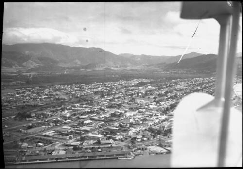 [Aerial view of unidentified town with port and hills in background] [picture] / [Frank Hurley]
