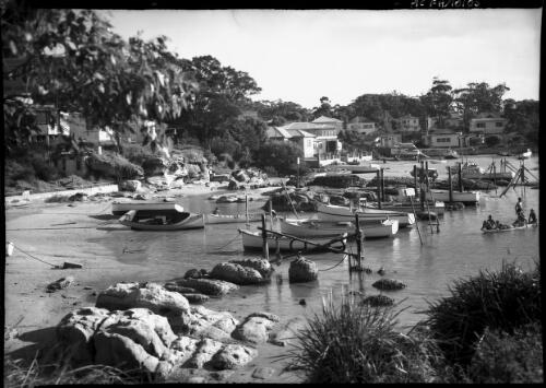 [Boats moored in small bay with houses built on shore] [picture] / [Frank Hurley]