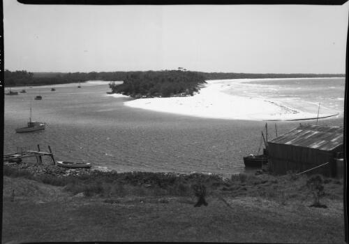 [Boats moored at the mouth of an inlet] [picture] / [Frank Hurley]