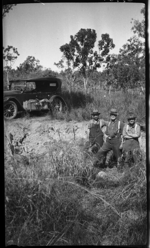 Ant hill near Mataranka [with three figures and a motor vehicle, Central Australia, ca. 1927] [picture] : [Central Australia] / [Frank Hurley]