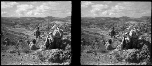 [Rocky arid landscape, three figures in Arab dress foreground, soldier on horseback behind] [picture] / [Frank Hurley]