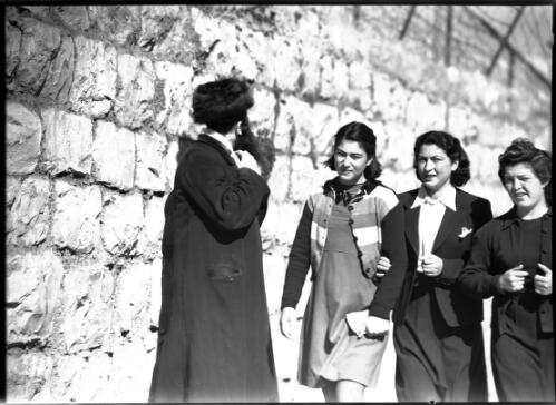 Jerusalem [Israel, elderly man with hat and three women in western dress, wall behind] [picture] / [Frank Hurley]