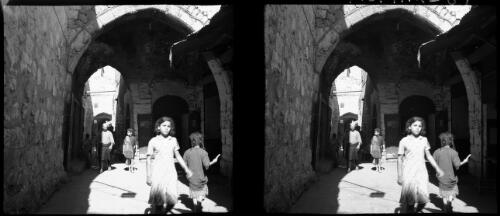 A passage in old Tyre [figures] [picture] : [Lebanon, World War II] / [Frank Hurley]