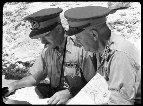 [Two men in military uniform, portrait, seated, looking at papers] [picture] / [Frank Hurley]
