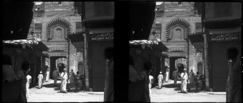 [Street scene, figures, "Ibrahim Botr..." visible on a sign] [picture] / [Frank Hurley]