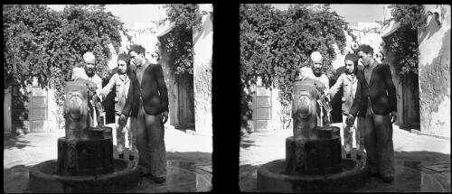 Derna [three men at a fountain] [picture] : [Libya, World War II] / [Frank Hurley]