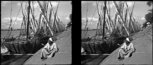 Felluccas at sea [docked, man seated in foreground] [picture] : [Egypt, World War II] / [Frank Hurley]