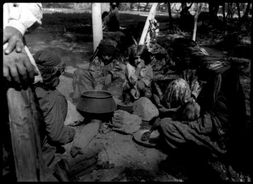 Kurdish women preparing a meal in a village behind Kermanshah [Kurdestan] [picture] : [Iran, World War II] / [Frank Hurley]