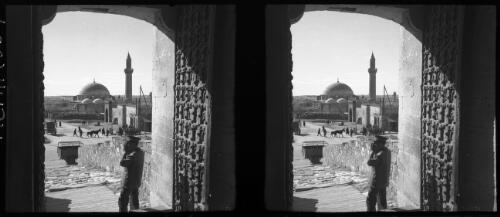 Scene Acre [man taking a photograph, mosque in the distance] [picture] / [Frank Hurley]