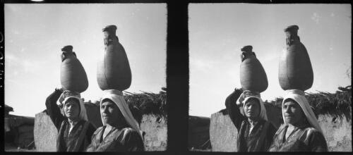 Women with water jars on head Bethlehem [two women, portrait shot] [picture] / [Frank Hurley]