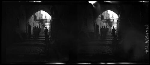[Cobblestone street, stepped under archway, figures] [picture] / [Frank Hurley]