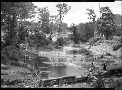 [Unidentified bush scene, including two people crossing a river, Australia] [picture] / [Frank Hurley]