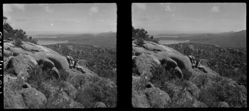 [Two seated figures on rocky outcrop in foreground ca. 1938-1947] [picture] : [Tasmania] / [Frank Hurley]