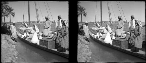 Scenes near Qurna, the legendary site of the Garden of Eden [several Arabs, in a large canoe with a box and a rope, and on a riverbank, and a river, 1944] [picture] : [Iraq, World War II] / [Frank Hurley]