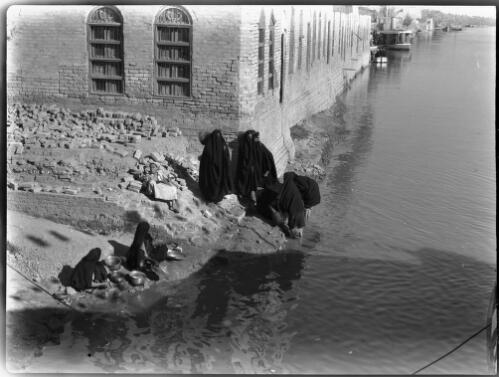 [Several figures washing in a river by the corner of a building, 1944] [picture] : [Iraq, World War II] / [Frank Hurley]