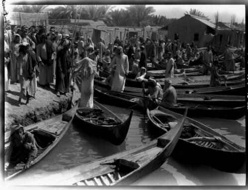 [Many canoes pulled in together and men talking, 1944] [picture] : [Iraq, World War II] / [Frank Hurley]