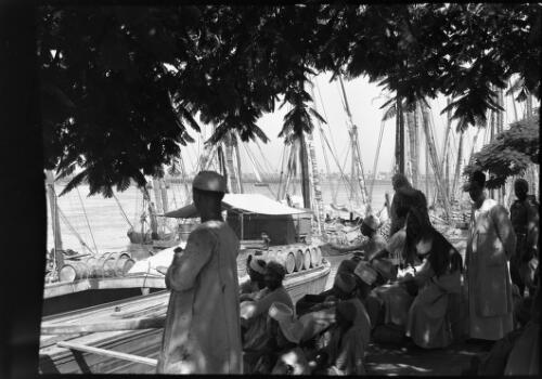 Cairo [figures on shore and boats on a river, framed by leaves] [picture] : [Cairo, Egypt, World War II] / [Frank Hurley]