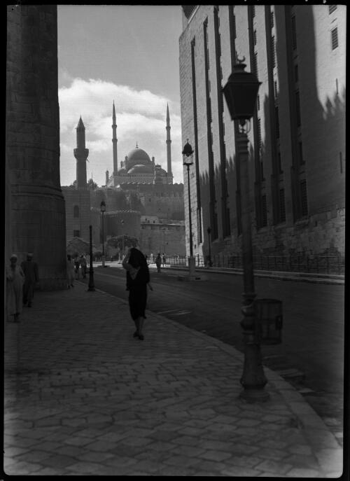 View looking towards the Citadel surmounted by the great Mahomed Aly Mosque [Muhammad Ali Mosque, with figures, lamp post and paving] [picture] : [Cairo, Egypt, World War II] / [Frank Hurley]