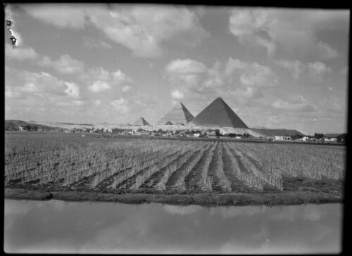 [A ploughed field and a river, and beyond, three large and several smaller pyramids] [picture] : [Cairo, Egypt, World War II] / [Frank Hurley]