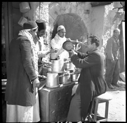 Village scenes shot at Misr studies on set [five figures with pots, one figure in military uniform] [picture] : [Cairo, Egypt, World War II] / [Frank Hurley]