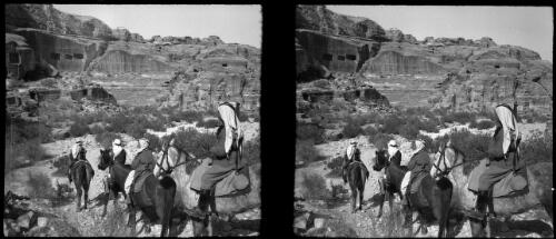 Our escort precedes us down into the valley [four figures riding beasts of burden, Petra] [picture] : [Jordan, World War II] / [Frank Hurley]