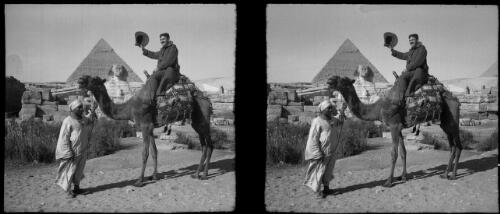An Australian at the Pyramids [waving a hat and seated on a camel] [picture] : [Egypt, World War II] / [Frank Hurley]