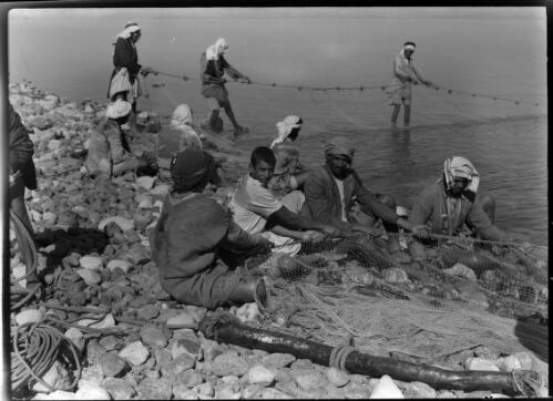 Fishermen landing the nets at Galilee [figures seated and standing] [picture] : [Galilee, World War II] / [Frank Hurley]