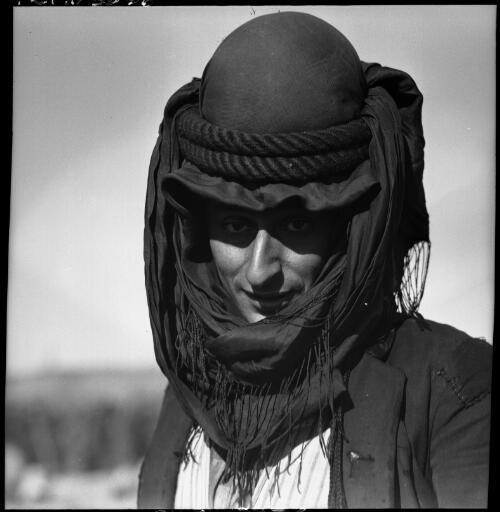 [Figure wearing a very ornate domed headdress and scarves] [picture] : [Portrait Studies, Libya, World War II] / [Frank Hurley]