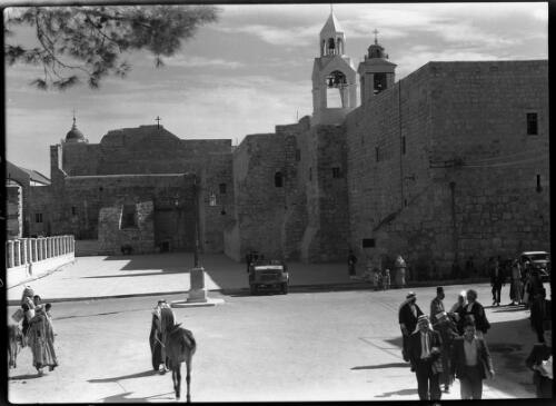 Church of Nativity Bethlehem [with figures, vehicles and an animal, in the street, ca. 1942] [picture] / [Frank Hurley]
