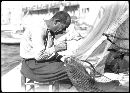 Mending fishing net Acre [Palestine] [picture] / [Frank Hurley]