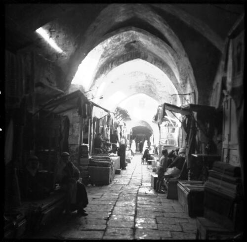 Jewish settlement, typical scenes round a Jewish village N Palestine [arcade or cloister with markets and street vendors] [picture] / [Frank Hurley]