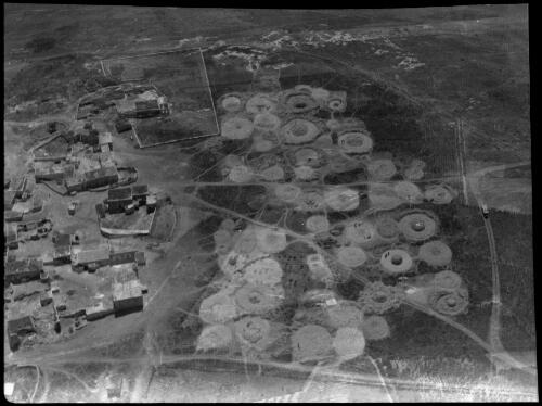 The circles are dumps of grain & straw where the grain is trodden out by the animals moving round in a circle, aerial view looking down onto threshing floors [picture] / [Frank Hurley]