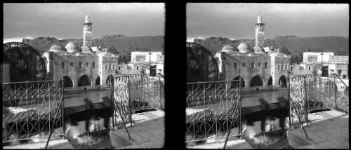 Waterwheels Hama [view across river from balcony to town buildings and waterwheel] [picture] : [Syria, World War II] / [Frank Hurley]