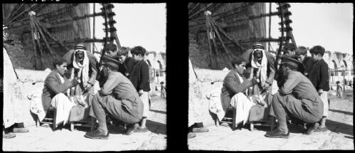 Hama [townspeople chat with uniformed figure, waterwheel in background] [picture] : [Syria, World War II] / [Frank Hurley]