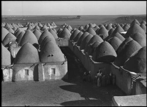 Typical mud-domed village Northern Syria [villagers gathered in foreground] [picture] / [Frank Hurley]