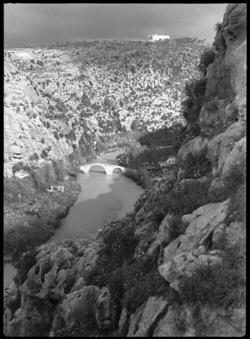Wady-El-Kalb (Dog R) [general view of the river, bridge and surrounding hilly countryside] [picture] / [Frank Hurley]