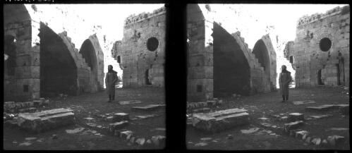 The Crac-de-Chevalier, one of the finest preserved of the Crusader fortresses in N. Syria [interior view with figure] [picture] / [Frank Hurley]