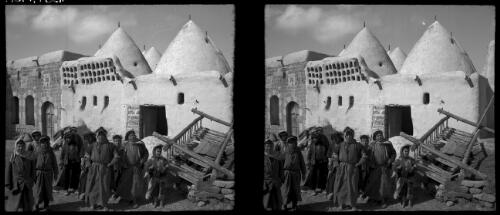 Curious beehive mud village between Hama & Homs Syria [street scene with villagers] [picture] / [Frank Hurley]