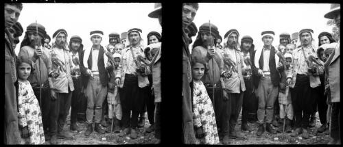 Falconers of Banias Syria [four falconers and their birds surrounded by men and children] [picture] / [Frank Hurley]