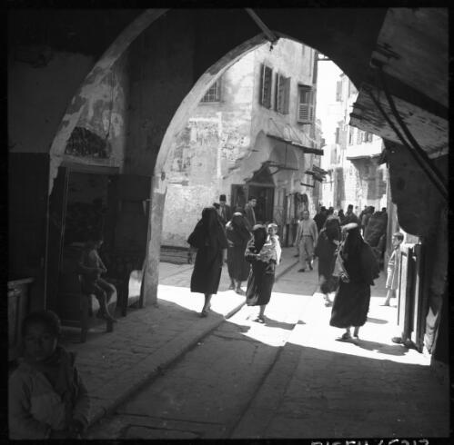 Scenes in Tripoli, Syria [busy souq scene, with seated child on left] [picture] / [Frank Hurley]