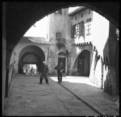 Scenes in Tripoli Syria [souq scene, view through archway including two figures] [picture] / [Frank Hurley]