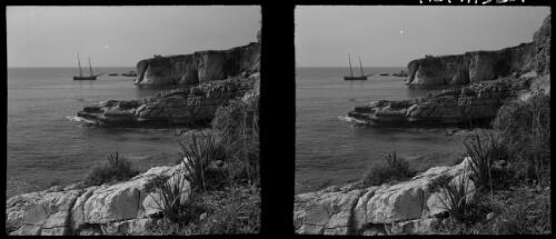 Views along the Syrian Coast near Junei, stereos [rocky outcrops to the sea, a boat in the distance] [picture] : [Syria, World War II] / [Frank Hurley]