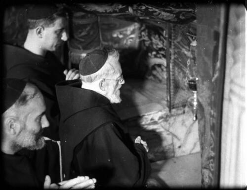 Church of the Nativity and monks praying, Grotto of the Nativity & at the manger [three Franciscan monks at prayer in the Chapel of the Manger, Bethlehem] [picture] / [Frank Hurley]