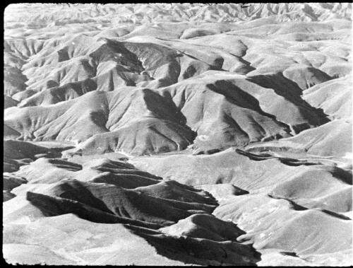Aerial & other shots of the Jordan to the Baptismal site below Allenby Bridge [aerial view of mountainous terrain] [picture] / [Frank Hurley]