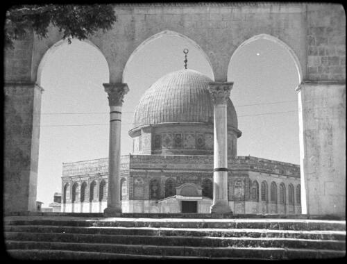 The Haram Esh Sharif (Mosque of Omar) [view of the Dome of the Rock, Jerusalem, as seen through the arches of the Stairs of Scales of Souls] [picture] / [Frank Hurley]