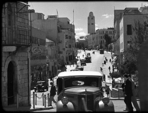 Modern streets & buildings Jerusalem [busy city street scene, HaMelekh David Street New City, with Jerusalem YMCA in the distance, 1] [picture] / [Frank Hurley]