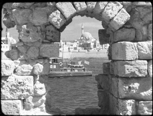 Ras Naqura, headland & Acre, Palestine [view of Al-Jazzar Mosque framed through stone arch, 2] [picture] / [Frank Hurley]