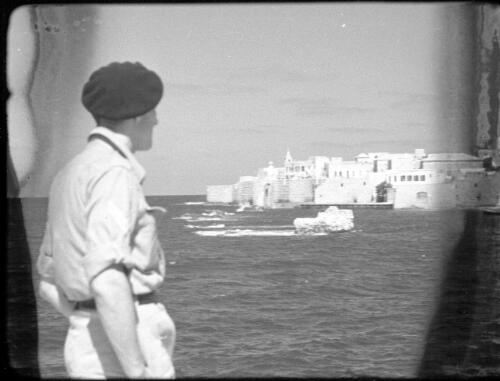 Ras Naqura Headland & Acre [army figure in foreground looking across Akko Bay] [picture] / [Frank Hurley]