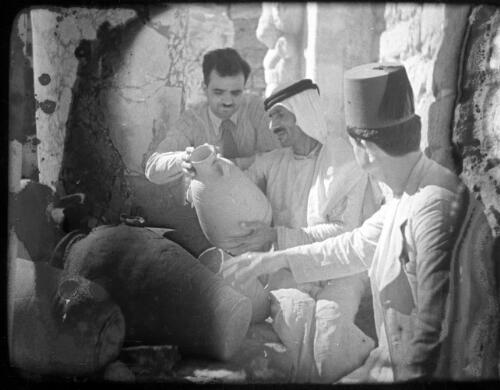 Making clay pottery & Alskelon ruins [three men inspecting pottery] [picture] / [Frank Hurley]