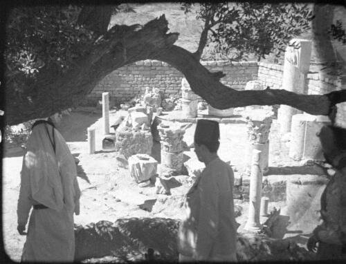 Making clay pottery & Alskelon ruins [three figures amongst the fallen ruins of Ashkelon] [picture] / [Frank Hurley]